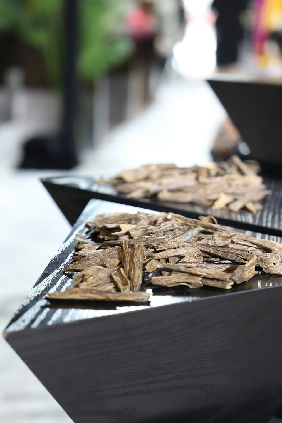Piles of rough wood chips sit in two black containers.